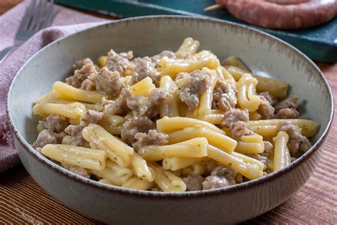 Piatto di pasta cremosa con salsiccia e spinaci