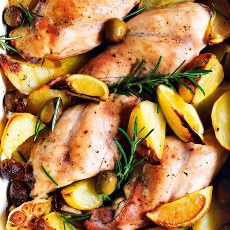 Pollo e coniglio crudi in una teglia con limone e erbe aromatiche