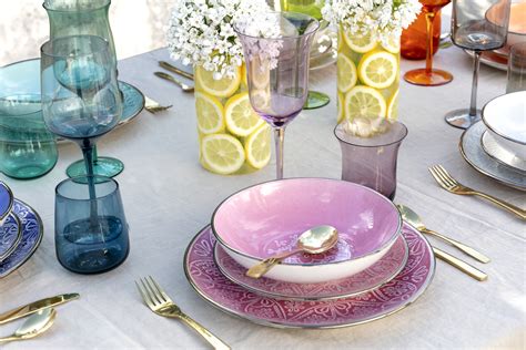 Tavola apparecchiata con piatti di diverse forme e colori