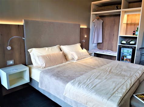 Interno di una camera d'albergo con letto, TV e frigorifero