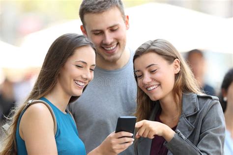 persone che ridono guardando un telefono