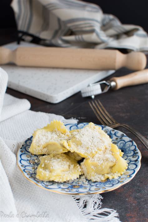 Un piatto di ravioli di gallina conditi con pancetta e scamorza